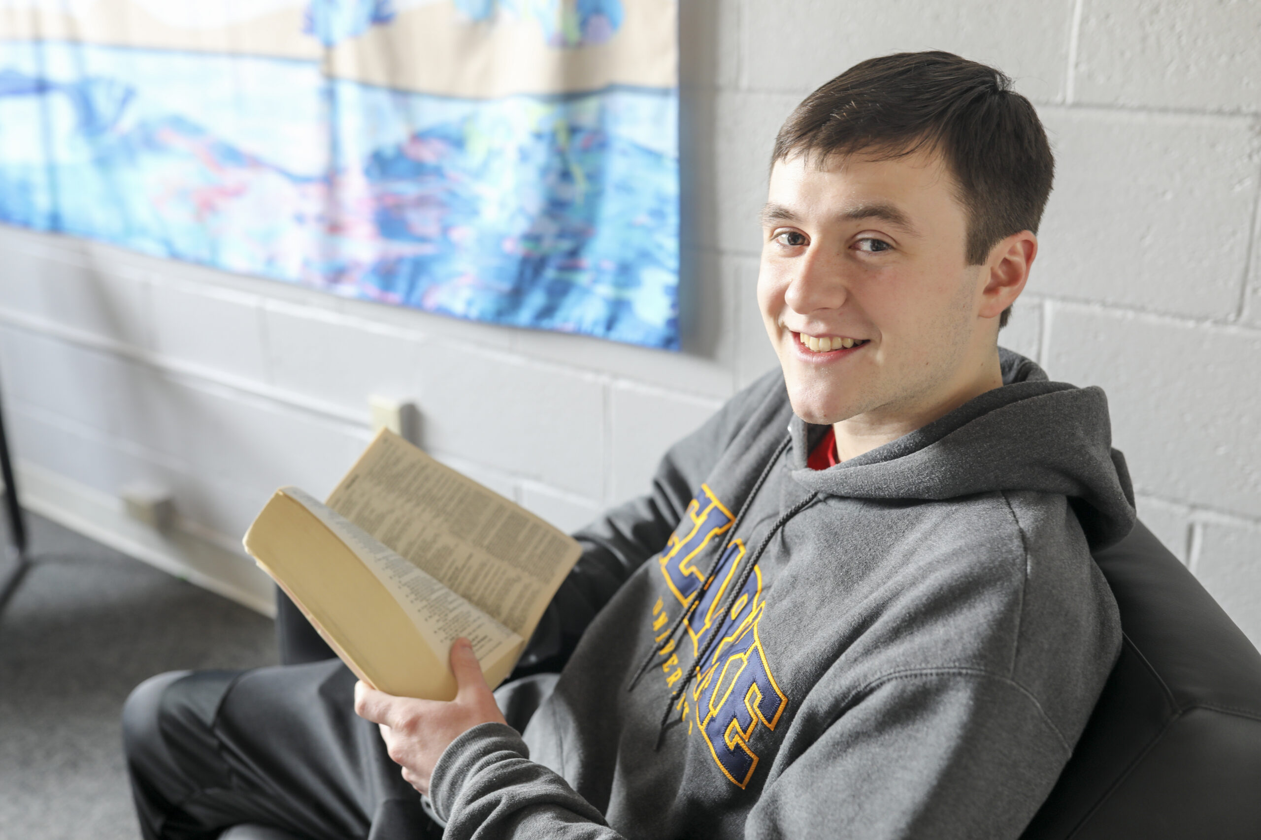 Clarke University Student reading on campus.