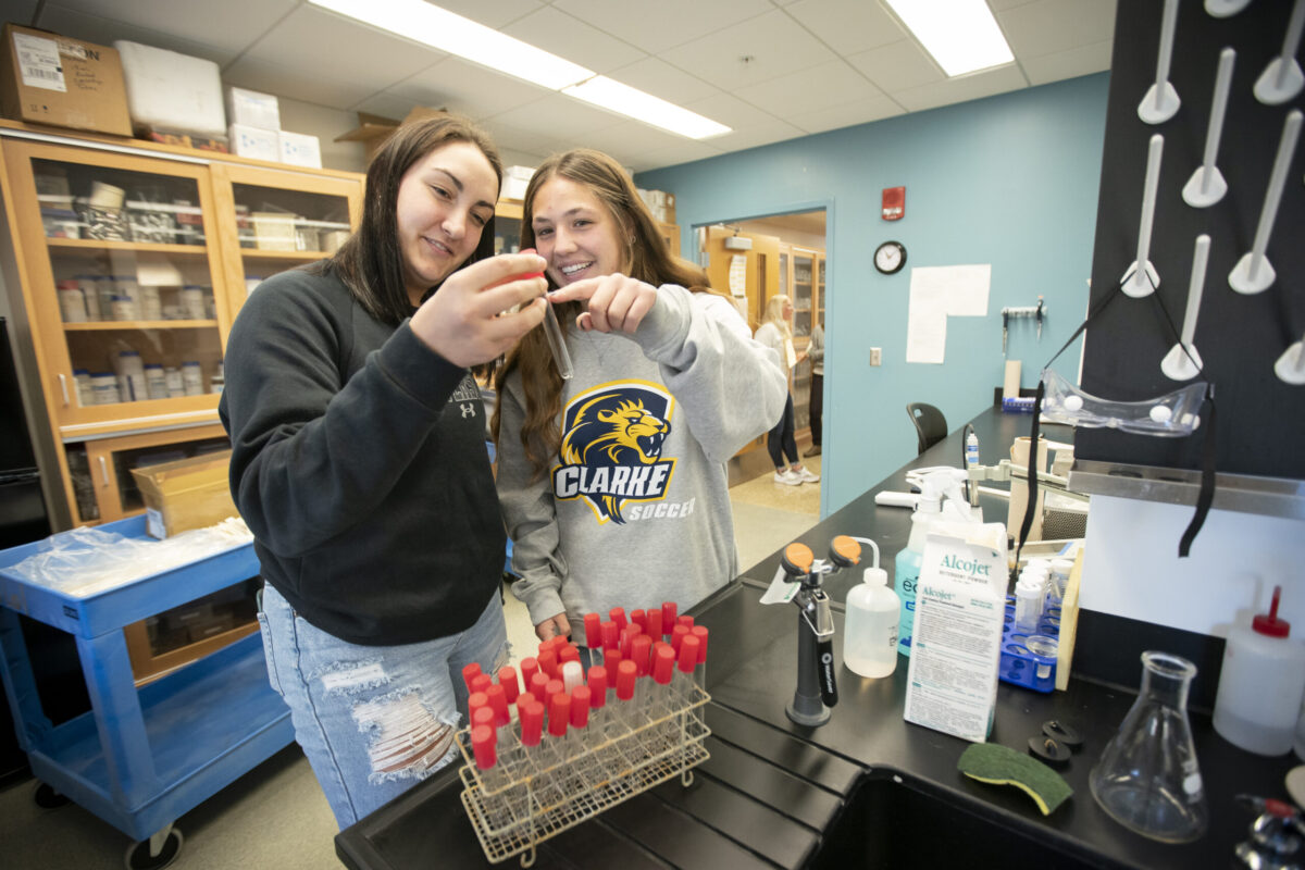 Two young women looking at a test tube in a science classroom. - Full Size