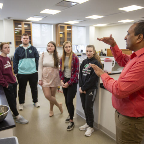 A teacher lecturing to his students in a science classroom.