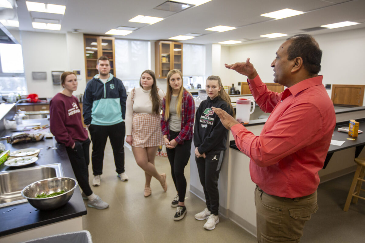 A teacher lecturing to his students in a science classroom. - Full Size