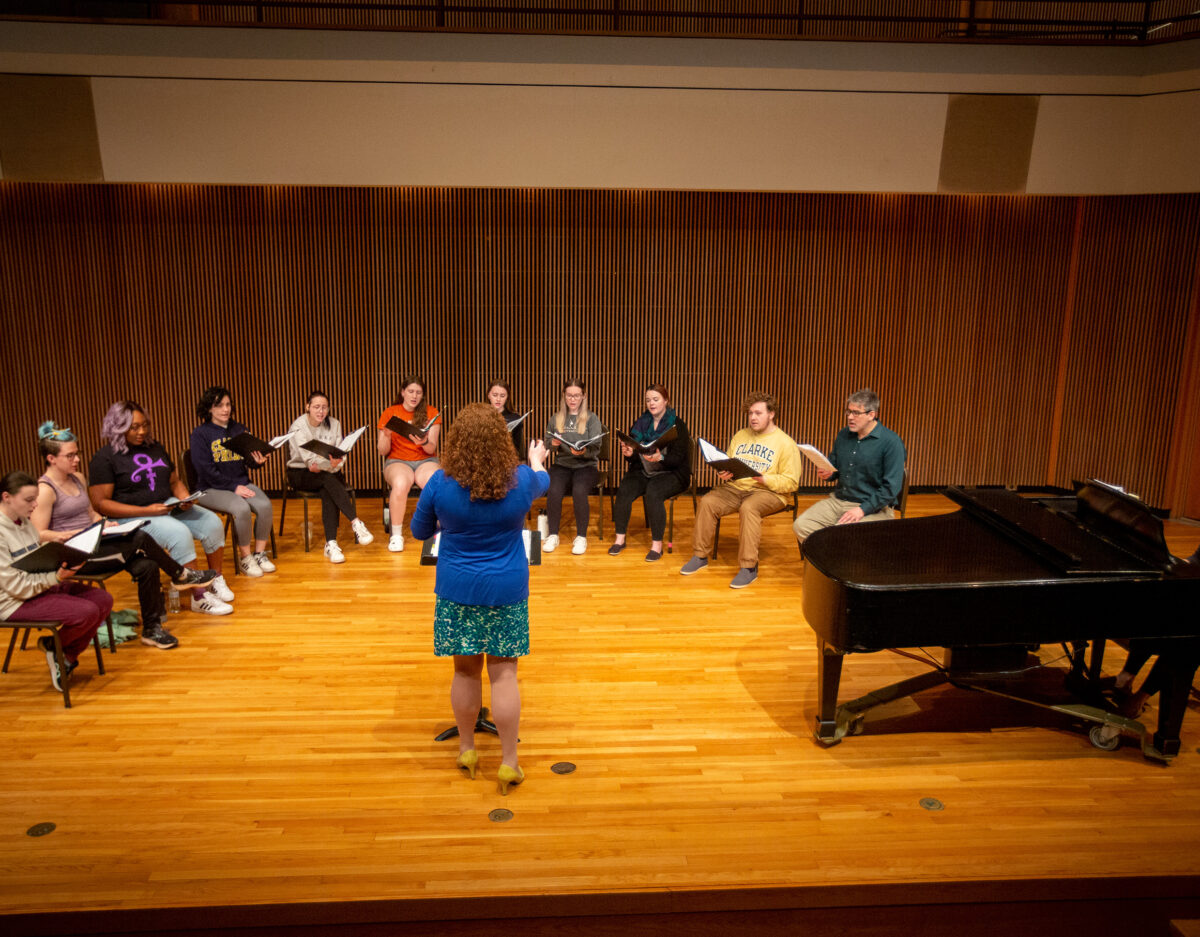 A female professor leading a full choir. - Full Size