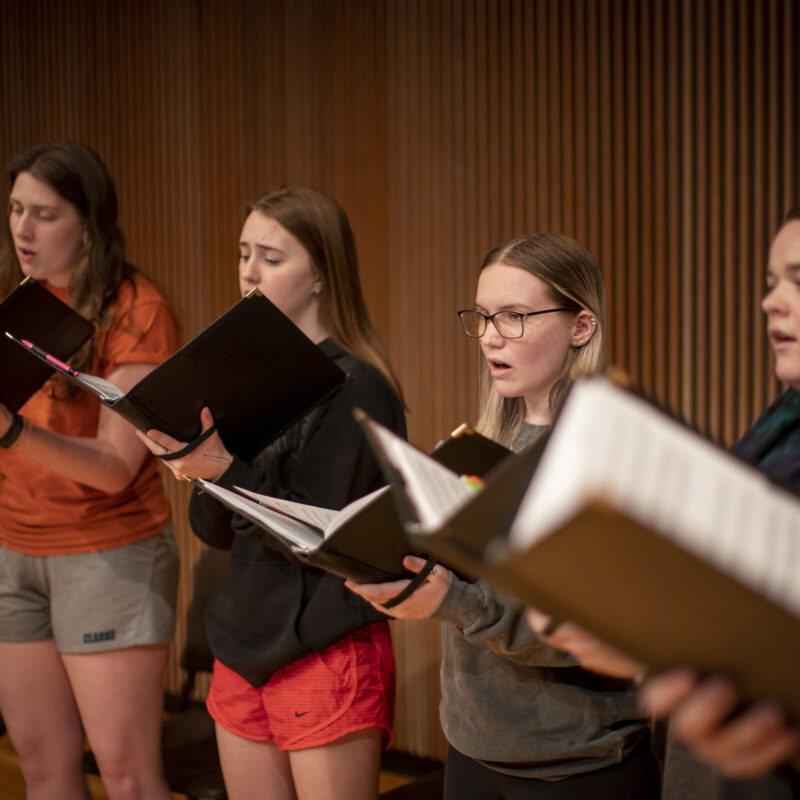 A group of female students singing in a choir.