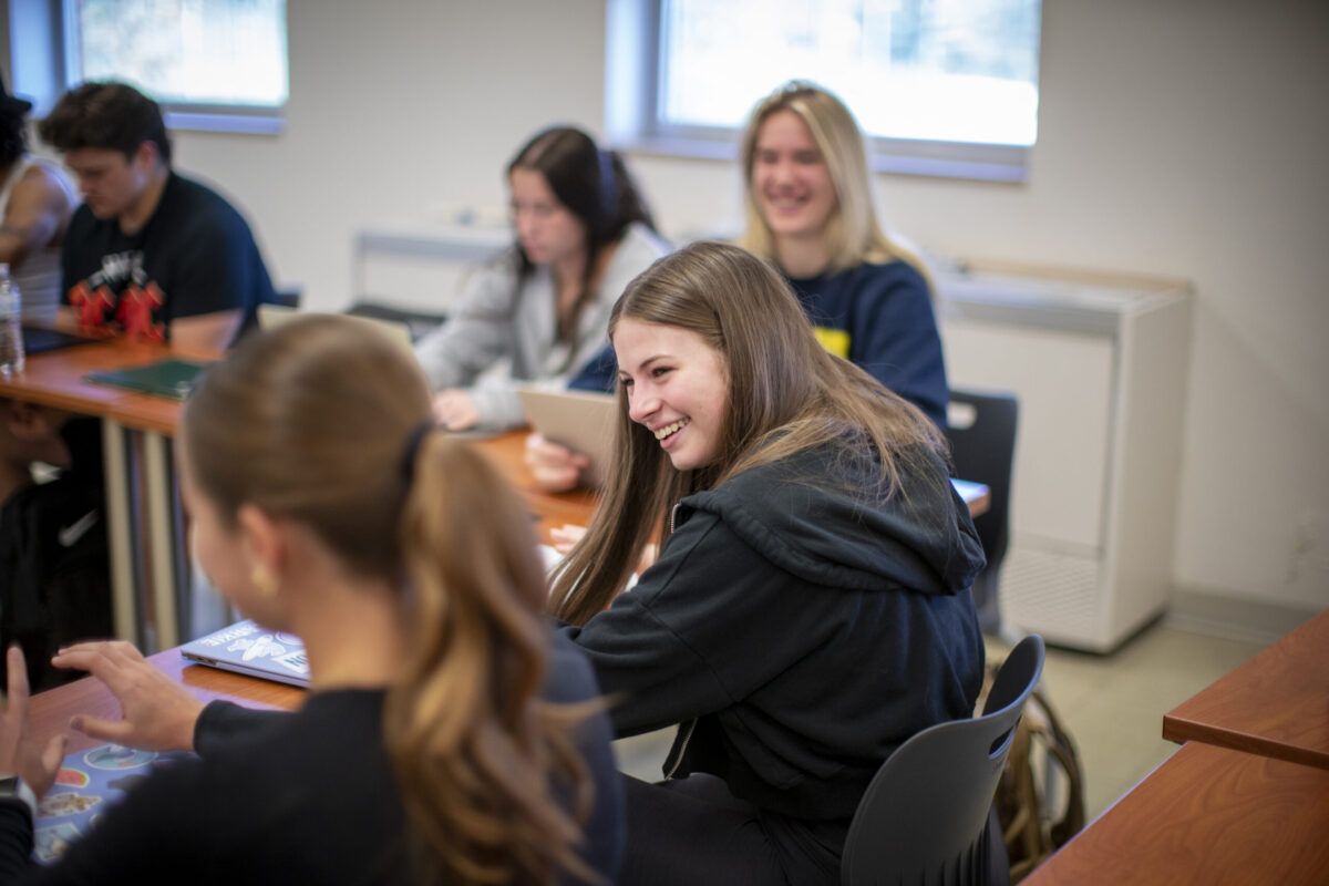 A female student smiling in class. - Full Size