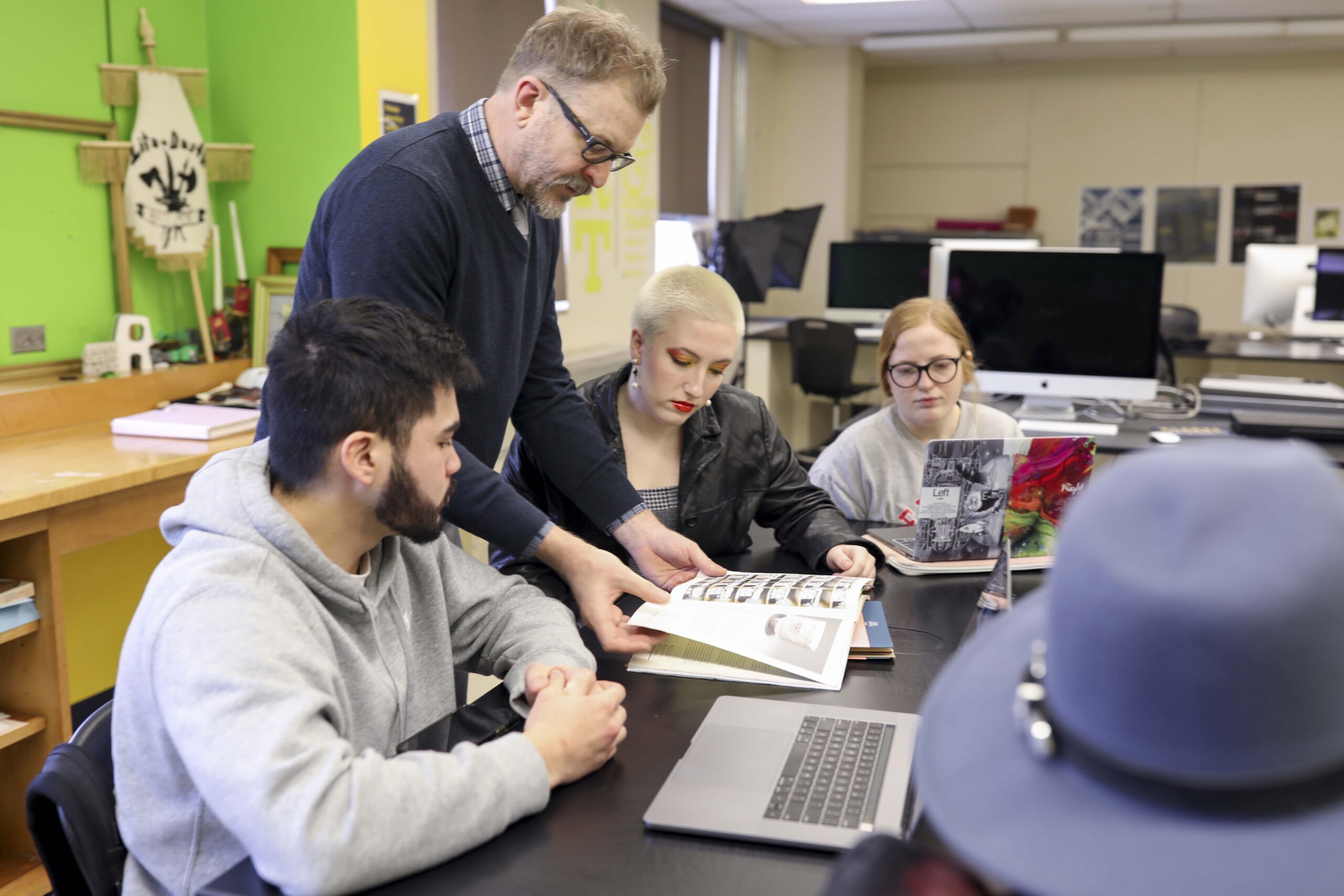 Clarke University Graphic Design Majors receiving instruction from professor.