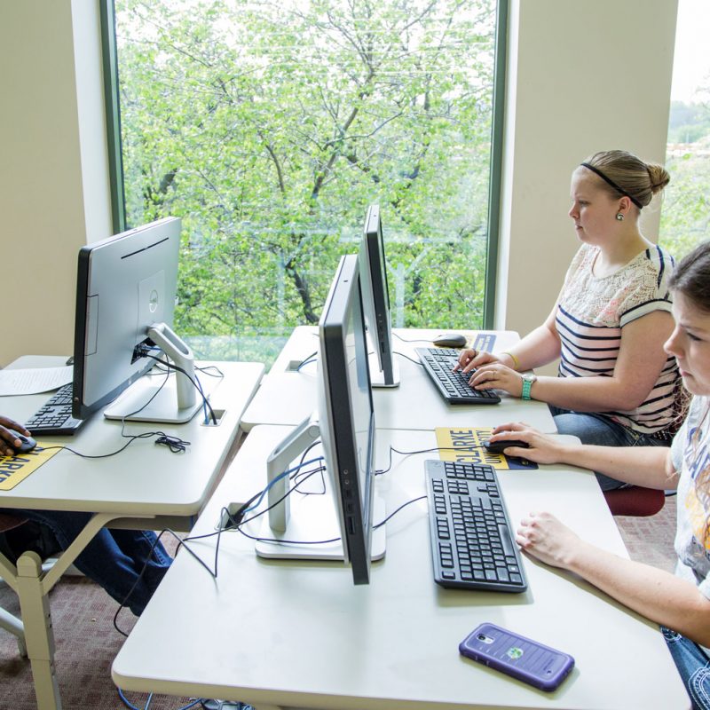 Clarke student working on her Communication Degree project in a computer lab