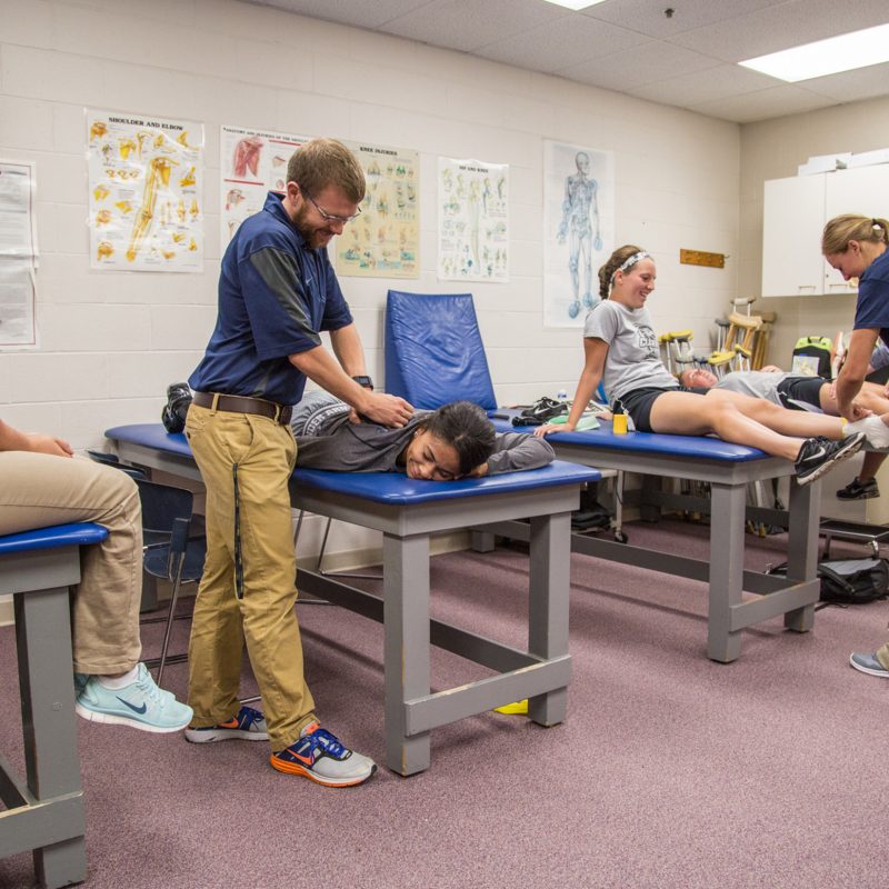Athletic Training degree students work on each other with feux injuries to practice proper techniques.