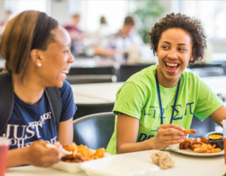 Clarke students laughing while eating at the dining hall