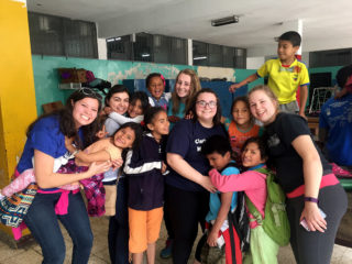 Clarke students with children while studying abroad in Equcador