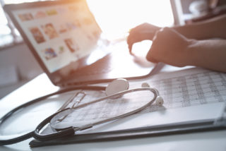 Close-up of hands of a nurse typing on laptop