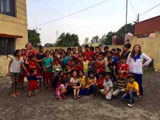 Clarke students with children while studying abroad in India