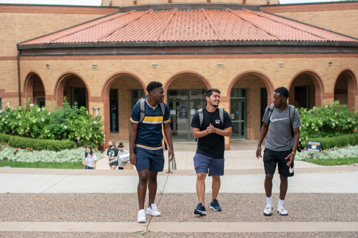 male-students-walking-outside - Full Size