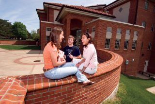 Exterior students in from of apartment