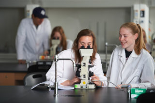 Clarke student looking at a microscope